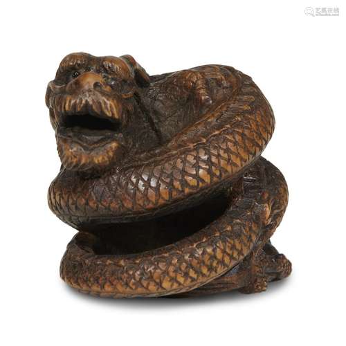 A Japanese carved wood netsuke of a coiled three clawed dragon, possibly early Hida school