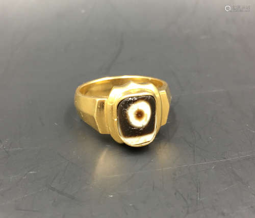 A GOLD RING WITH DZI