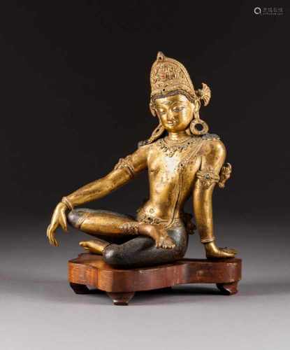 SITZENDE GOTTHEIT Indien/Nepal, wohl 18. Jh. Bronze, part. vergoldet. H. 25,8 cm (Figur). Unterseite