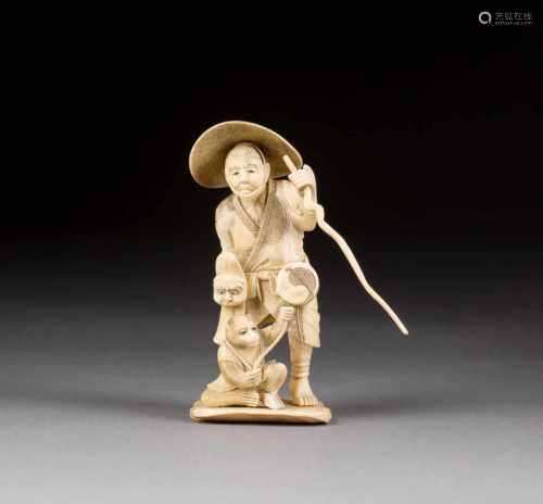 OKIMONO: STRAßENKÜNSTLER UND AFFE Japan, um 1900 Elfenbein, geschnitzt. H. ca. 12 cm. Figuren auf