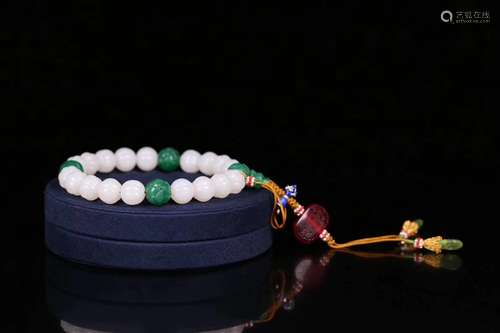 AN OLD HETIAN JADE CARVED BEAD STRING BRACELET