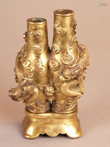 Magnificent Gilt Bronze Conjoined Double Vase - China, Qing Dynasty, 19th century, the<br />body heavily cast as two conjoined slender baluster vases  (height c.14,5 cm/ 16cm) decorated with two chilong dragons chasing the flaming jewel, each with sinuous bodies and bifurcated tails, surrounded by small scattered lingzhi clouds in relief, full round dragon heads ,elaborately engraved, w.c.12cm, weight appr.2084g, incised 6-character kaishu mark to the base ''Da Qing Qianlong Nian Zhi'', gilt slightly abraded, with a scallopped fitted bronze pedestal decorated with engraved flowering tendrils, appr.3,5x9x6,5cm, weight appr.353g