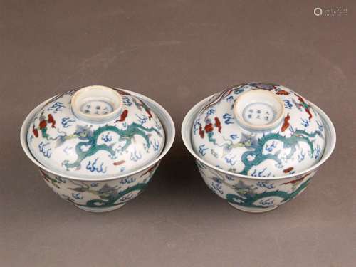 Pair of lidded bowls - China / republic period, pendants of two rice bowls with lids,<br />walls and lid painted with Doucai-style dragon and phoenix motif, also interior decoration, bottom and lid with underglaze blue 6-character brush mark ''Da Qing Yongzheng Nian Zhi'' in double ring, H. with lids about 9 / 9.5 cm, Dm.ca.12,2cm, lid not fit