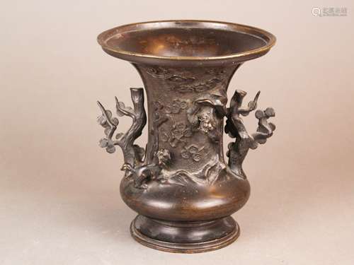 Bronze Vase - bronze vessel with a trumpet-like lip and constricted foot, tree branches in<br />relief at the neck over meandering background, lingzhi clouds as well as shishis, partly full plastic, handles in the shape of flowering trees, H.ca.18cm, Japan / China, Meiji period, slight signs of age