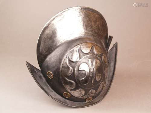 Schwarz-weißer Morion/Helm - süddeutsch, Ende 16.Jh./17.Jh., Eisen, teilweise geschwärzt,<br />zweiteilig geschlagene Kalotte mit hohem Kamm, seitlich jeweils stilisierte heraldische Lilie umgeben von Fischblasendekor, umlaufende Futternieten mit geprägten Zierrosetten aus Messing, spitz zulaufende Krempe, Ränder gebördelt,im Nacken vernietete eiserne Federbuschtülle, Alters- bzw. Gebrauchsspuren, H.ca.28cm