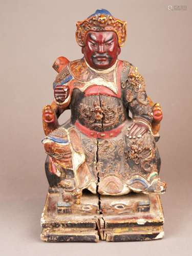 Figure of the Chinese Guardian Warrior Guan Gong / Guandi - China, Ming-style but later<br />(probably 18th century), carved wood, paint and gilt, the attribute in his right hand is missing, the red faced deity wears a helmet and half armor, half long robe, both adorned with half round dragon motifs, paint later restored, some minor flaws and damages, large front crack, H.ca.31cm