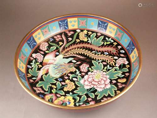 Large cloisonne foot bowl - China 1st half of the 20th century, round shape with raised<br />wall on a low base, on inner and outer wall geometric and floral enamel decoration on differently colored backgrounds, in the mirror Fenghuang surrounded by flowering plants on a black background, dia. ca.37,5cm / H.ca.11cm, enamel with slight signs of age