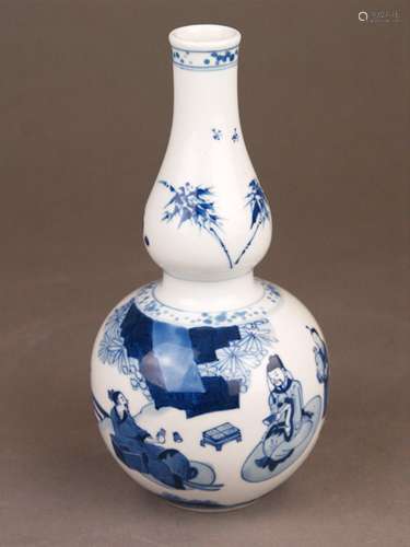 A blue and white double gourd porcelain vase - painted in inky tones of cobalt blue with<br />scholar figures and servants in a garden landscape, ornamental borders of blobby dots, unmarked, China, Qing-Dynasty, possibly Kangxi (1662-1722), c.8 5/16 in. (c.21cm) high