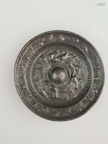 Miniature mirror - China, tin bronze with silver coating, round shape with relief tendrils<br />on the rim, dragon relief in the deepened well, in the style of the Tang-period, on the reverse partially copper efflorescence, dm.ca.5,5cm