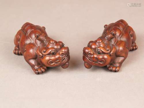 Pair of Chimeras / Bixie Figurines - China, fine wood carvings, counterparts of two<br />lion-like mythical creatures with curved hair (actually horns) and bifurcated long tails, L. / H.ca.9,5 / 4cm, ca.100 and 83g