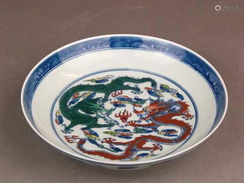 Doucai plate - porcelain with polychrome painting, deep bowl on round base ring, in the<br />well two five-claw dragons with flaming pearl, surrounded with small clouds and a double circle, at the edge cobalt blue border with waves, outer wall with other lingzhi cloud formations alternating with cranes, framed with double circles, in the bottom six-character mark in the double circle ''Da Qing Yongzheng Nian Zhi'', China, dm./H.:ca.19.5 / 4 cm