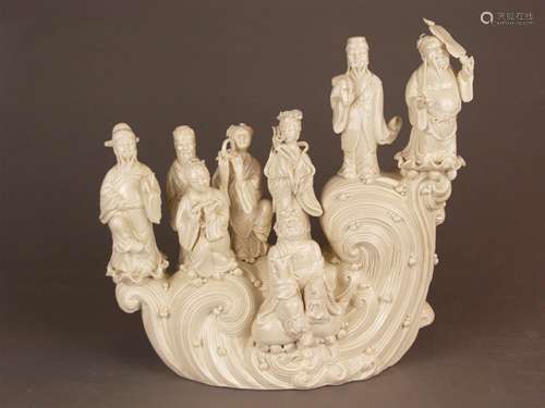 Blanc-de-Chine figure group ''The Eight Immortals'' - China, Dehua, cream-white porcelain,<br />detailed fully round representation of the Eight Immortals (Taoist saints and patron saints of Chinese mythology) as they are crossing the sea on a wave, the individual saints can be recognized by the attributes, i.a. fan, castanets, flower basket, calabash, bamboo cane and flute, stamped on the reverse: dehua seal in pumpkin shape and rectangular artist's mark, h.ca.34.5 cm, weight approx. 3.4 kg, fabric-lined storage brocade box enclosed