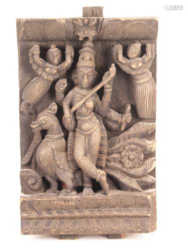 The Goddess Sarasvati with lute - South India 18th/19th.century, heavy folk relief<br />carving, probably from an procession chariot, shown below a kirttimukha (lion mask) the four-armed sarasvati (skt. catur-bhuja) goddess of the arts, wisdom, beauty and harmony, she stands in padasvastika on double lotus base, the main hands hold the Indian lute (skt. Vina), right hand with prayer beads (skt.mala), left hand with book (skt.pustaka), her head decorates the high hair crown jatamukuta, behind her is the peacock, her pack animal, the deity is flanked by Ganharvis (heavenly musician) with garlands, verso old suspension, wood outbreak on the backside in lower right, which was closed with wax, age - related cracks and bumps, abrasion, ca .45x26x7cm