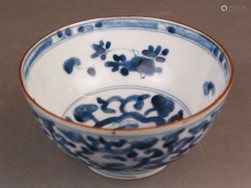 Porcelain blue and white bowl - China, Qing Dynasty, round  shape raised on a small stand<br />ring, painted in underglaze blue with blossoming (lotus) tendrils and ornamental border, brown edged rim, underglaze blue lozenge mark, smaller irregularities due to the production (bottom), Dm.ca.15cm/c.7cm high