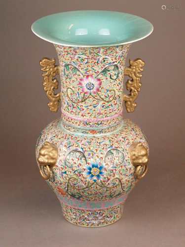 Vase - China, porcelain with lush painting in polychrome enamel colors, all covering<br />meandering lotus tendrils and flowers, horizontal ornamental borders, three fully round appliqués in the shape of lion heads with hinged mouth rings, chilongs as handles on the side, light blue glaze inside, Zhuanshu bottom mark ''Da Qing Qianlong-Nian Zhi '' in underglaze blue, H.ca.38cm, edge probably restored (discoloration)