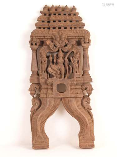 The goddess Lakshmi with peacock - India, 19th century, wood, folk carving, openwork, in<br />the center the goddess Lakshmi sitting on a peacock, flanked by two servants (shown smaller), over the head of Lakshmi a Kirttimukha lion mask, ornate architectural framing with two columns and temple-like finish, slightly bumped in the area of Kirttimukha, HxWxD: ca.48x21x4,5cm