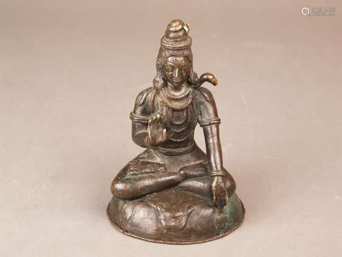 19th Century Nepalese bronze figure of Shiva, in seated position with one hand raised t<br />and serpents around the neck, seated on a tiger skin, c. 15cm high, trident missing