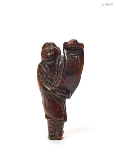 A WOOD NETSUKE OF A MAN WITH SCROLL, C. 1800 TO EARLY 1…