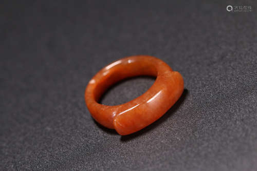A RED-GLAZED SADDLE SHAPED JADE RING