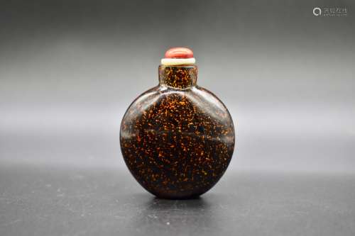 A small Chinese black hardstone with gold leaf snuff bottle