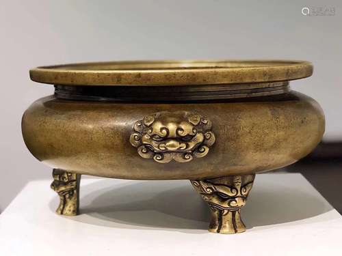 A BRONZE TRIPOD CENSER WITH 'LION' HANDLES