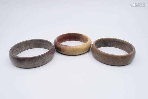 THREE JADE CARVED ARM BANGLES