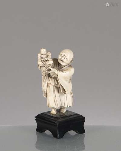 Netsuke en ivoire du Japon d'un vieillard portant un Bouddha de sa main gauche. H. [...]