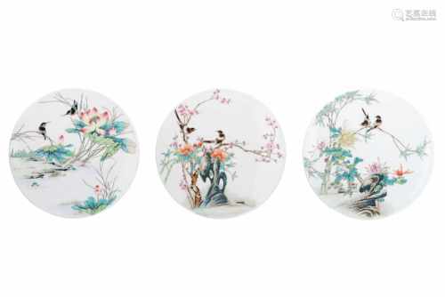 A lot of three round polychrome porcelain plaques, both decorated with flowers and birds.
