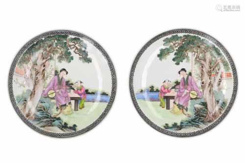A pair of polychrome porcelain dishes, decorated with a lady and little boy with books in a