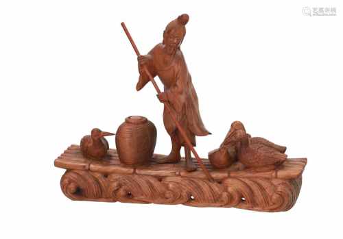 A carved wooden sculpture of a fisherman on a raft. China, 19th century. H. 20 cm.