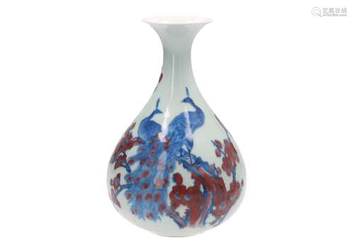 A blue and underglaze red porcelain vase, decorated with two peacocks on flower branches. Marked