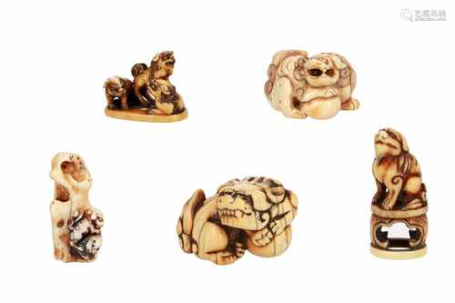 Lot of five netsuke, 1) Ivory shishi climbing on rock. H. 4 cm. 2) Ivory three shishi on base.