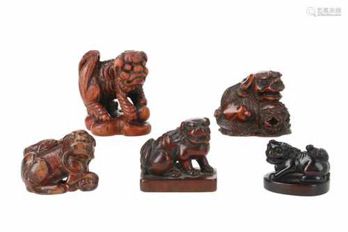 Lot of four netsuke and one seal netsuke, 1) Wooden shishi with ball on base. Signed Issai. H. 2,5