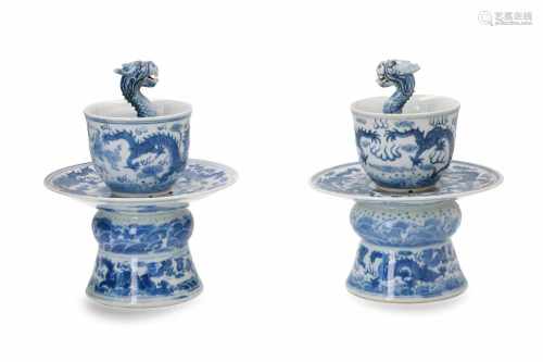 A pair of blue and white porcelain dragon puzzle cups on stand, decorated with dragons. Marked