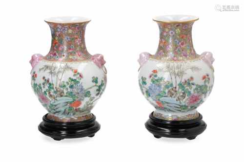 A pair of polychrome porcelain vases on wooden base, decorated with flowers and birds. Handles in