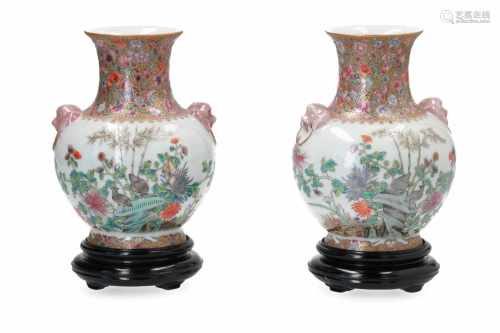 A pair of polychrome porcelain vases on wooden base, decorated with flowers and birds. Handles in