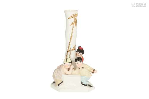 An polychrome porcelain sculpture, depicting two arm wrestling boys and a girl looking at them
