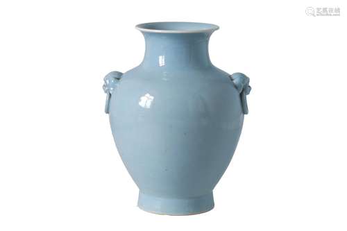 A clair de lune glazed porcelain vase with handles in the shape of animal heads, holding a ring.