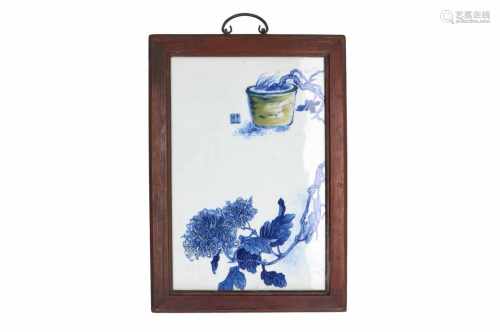 A blue and white porcelain plaque in wooden frame, decorated with flowers in the style of Wang Bu.