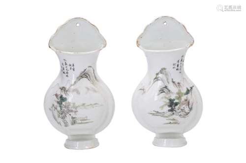 A pair of polychrome porcelain wall vases, decorated with a mountainous river landscape. Marked with