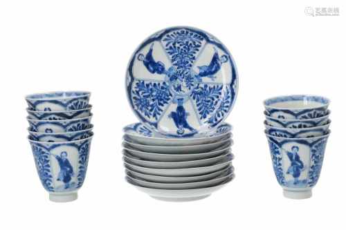 A set of nine blue and white porcelain cups with saucers, decorated with figures and flowers in