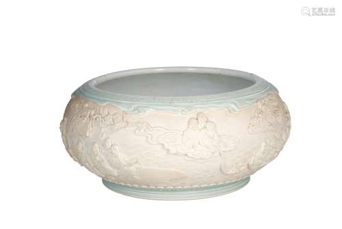A celadon glazed porcelain bowl, decorated with several scenes with figures in relief. Unmarked.