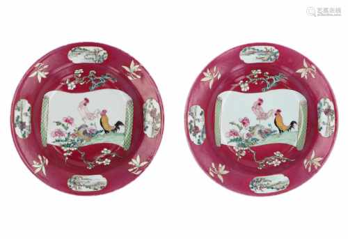 A pair of famille rose ruby-ground porcelain deep dishes, enameled at the centre with an open scroll
