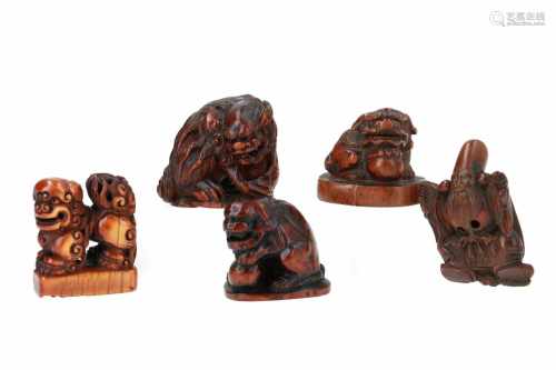 Lot of four netsuke and one seal netsuke, 1) Wooden shishi with ball on base. H. 3 cm. 2) Wooden