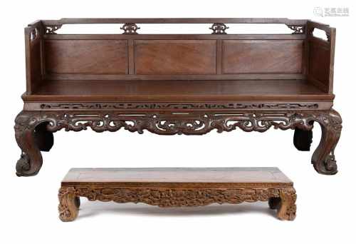 A rosewood carved wooden couch with a seperate foot rest. China, ca. 1900. Dim. 230 x 105 x 75 cm (