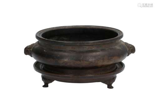 A bronze censer on bronze tripod base. The handles in the shape of animal heads. Marked with seal