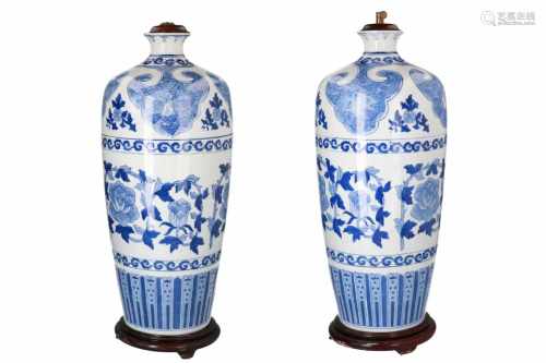 A pair of blue and white porcelain lamp stands on wooden base, decorated with flowers. Unmarked.