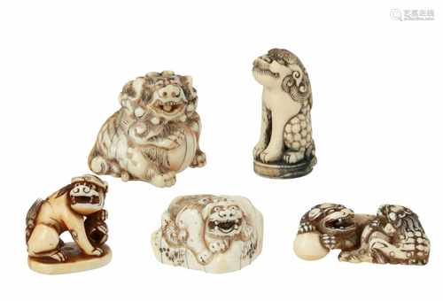 Lot of three netsuke and two seal netsuke, 1) Ivory shishi on rock. L. 4 cm. 2) Ivory reclining