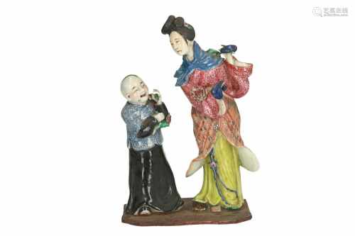 A polychrome porcelain sculpture, depicting a woman and boy with flowers. Marked with seal mark.