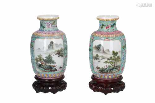A pair of polychrome porcelain vases on wooden base, decorated with flowers and landscapes in